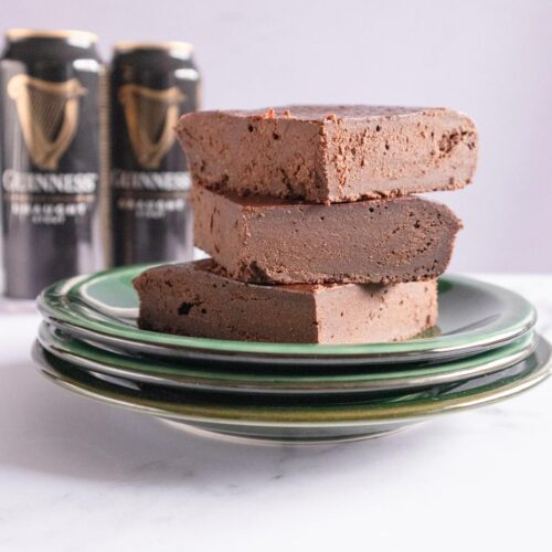 Una pila de dulce de chocolate en un plato junto a una lata de Guinness.